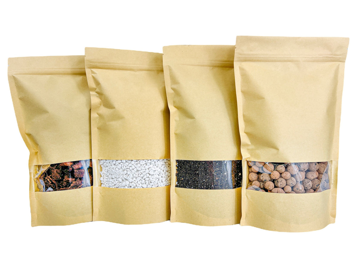 Quatre sacs en papier kraft avec fenêtres transparentes, contenant du terreau, des billes d'argile, et d'autres éléments pour rempotage