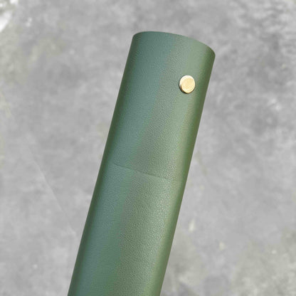 Gros plan sur la surface d'un tapis de rempotage en simili cuir vert foncé, avec des détails sur l'imparfait