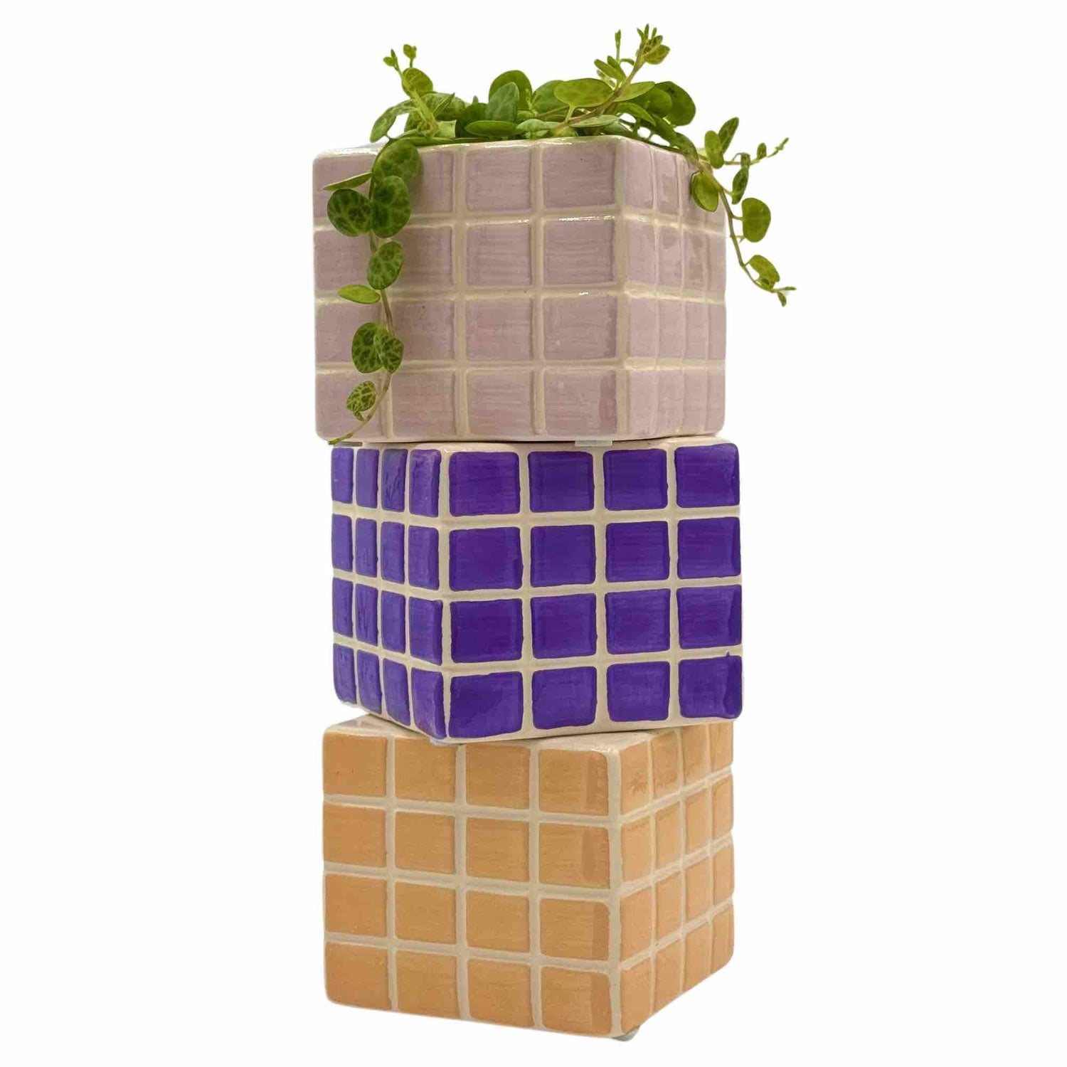 Trois cache-pots "Pixel" en céramique superposés, pastel clair, violet et ocre, avec une petite plante verte