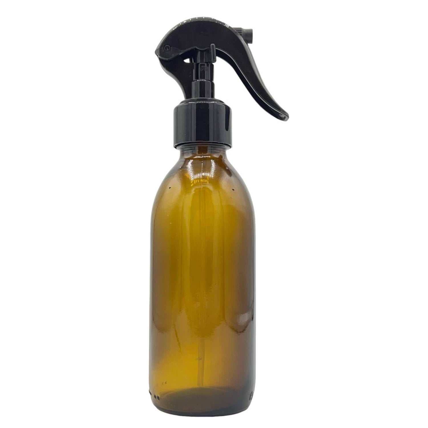 Un pulvérisateur en verre ambré avec une tête de vaporisateur noire et une gâchette latérale, sur fond blanc
