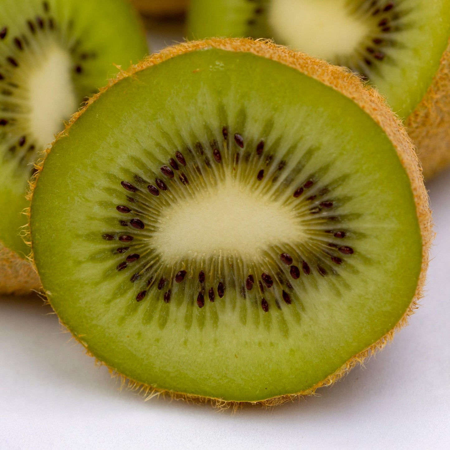 Actinidia deliciosa Jenny, tranche de kiwi frais et juteux, révélant sa chair verte et ses petites graines noires.