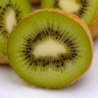 Actinidia deliciosa Jenny, tranche de kiwi frais et juteux, révélant sa chair verte et ses petites graines noires.