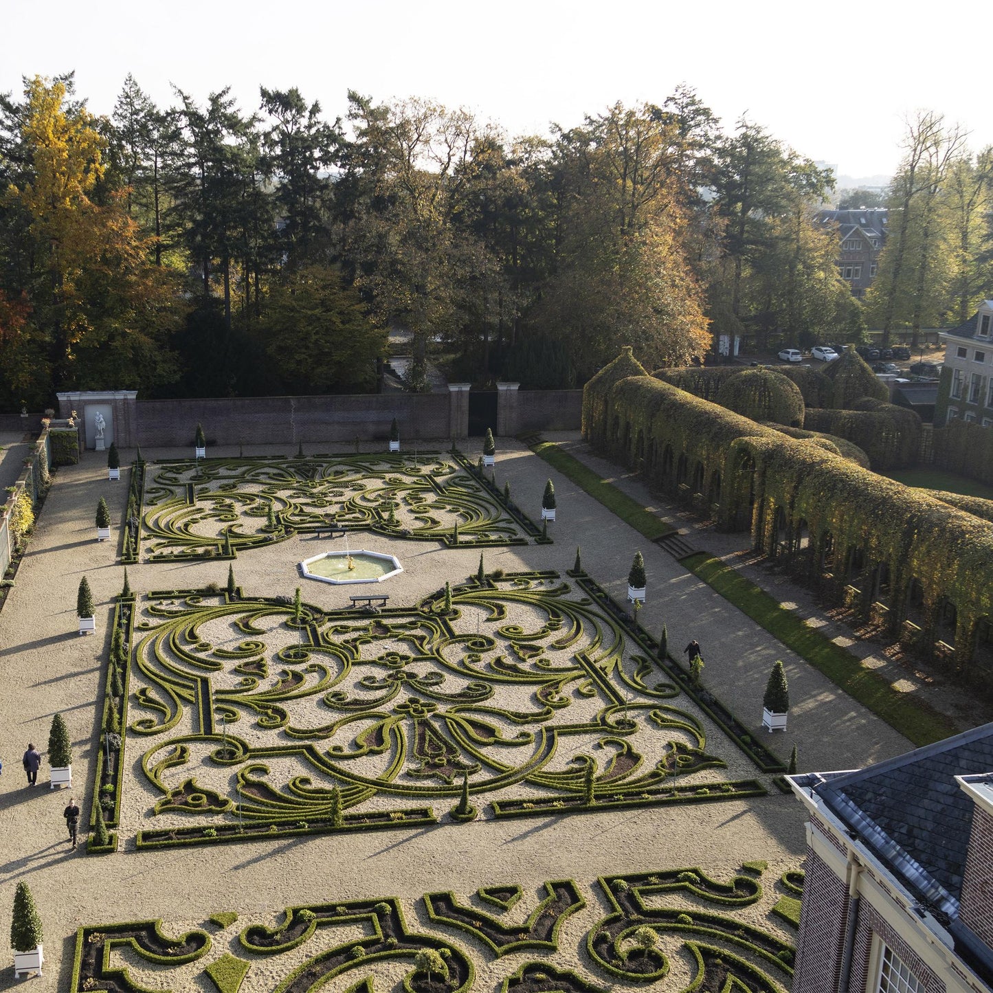 BetterBuxus Babylon Beauty. Vue aérienne d'un grand jardin formel avec des parterres de buis taillés en arabesques et des allées de gravier.