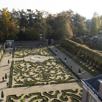 BetterBuxus Babylon Beauty. Vue aérienne d'un grand jardin formel avec des parterres de buis taillés en arabesques et des allées de gravier.